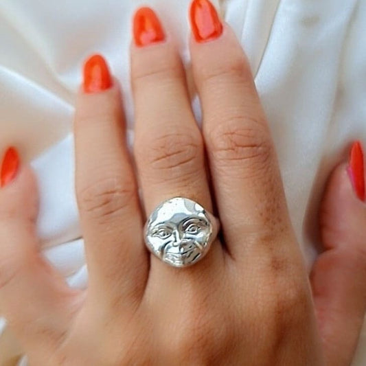 May include: A silver ring with a face design